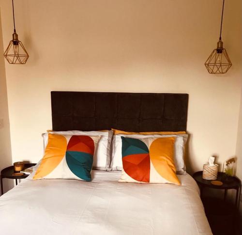 a bedroom with a bed with two colorful pillows at The TollHouse in Stirling