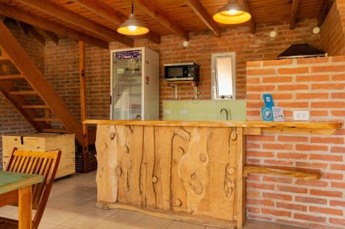 cocina con encimera de madera y pared de ladrillo en Hostal La Gran 7 en Villa Gesell