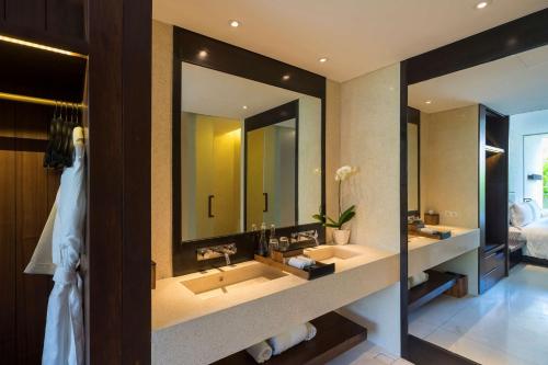a bathroom with two sinks and a large mirror at Studios at Alila Seminyak in Seminyak