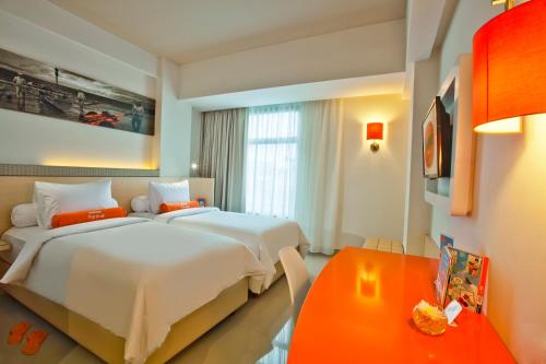 a hotel room with two beds and a table at HARRIS Hotel Seminyak in Seminyak
