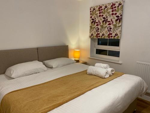 ein Schlafzimmer mit einem Bett mit zwei Handtüchern darauf in der Unterkunft Spacious 2 Bed House for Corporate and Family Stays in Basingstoke
