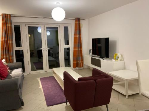 a living room with a couch and a tv at Spacious 2 Bed House for Corporate and Family Stays in Basingstoke