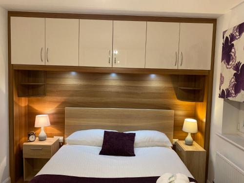 a bedroom with a large white bed with two night stands at Spacious 2 Bed House for Corporate and Family Stays in Basingstoke