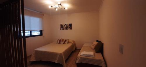 Habitación pequeña con 2 camas y ventana en Monoambiente Céntrico en Mendoza