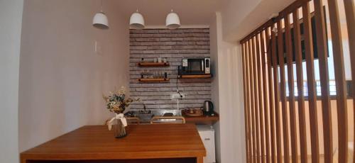 cocina con mesa de madera y pared de ladrillo en Monoambiente Céntrico en Mendoza