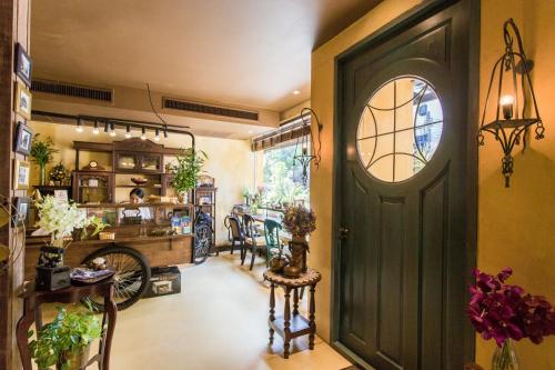 a hallway with a green door and a dining room at Old Capital Bike Inn - SHA Certified in Bangkok