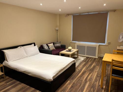 ロンドンにあるStunning Studioのベッドとソファ付きのホテルルーム