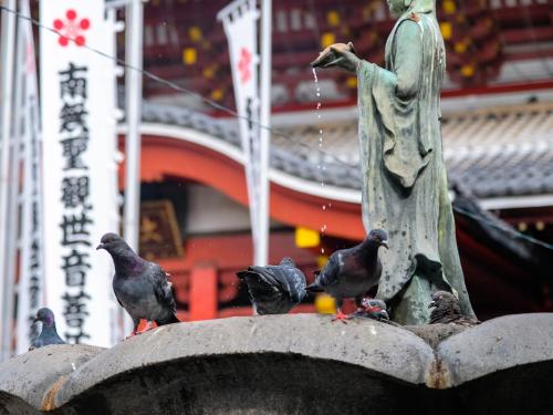a group of pigeons standing on top of a fountain at Hotel Abest Osu Kannon Ekimae Hane no Yu in Nagoya