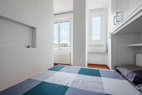 ein Schlafzimmer mit einem Bett und zwei Fenstern in der Unterkunft Nice and Cozy studio in Porta Romana by Easylife in Mailand