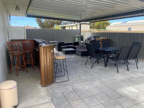 a patio with a table and chairs and a couch at Investigator Beach Breeze Apartments U2 in Kingscote