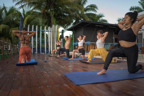 un grupo de personas en una clase de yoga en The Yak Lake House - Hostal en Bacalar