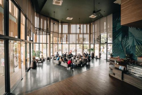 a group of people sitting in a large room with windows at The Signature Hotel Airport in Hat Yai