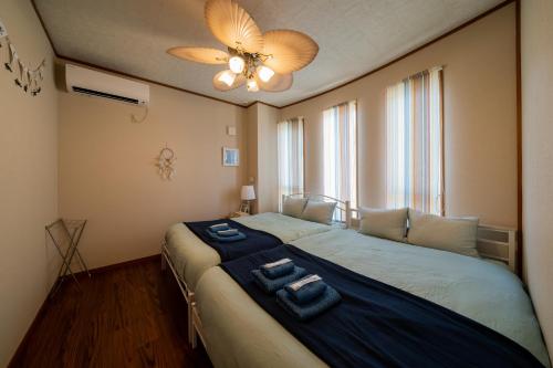 a bedroom with a large bed with two towels on it at ペンション ラナカイハウス沖縄 in Onna