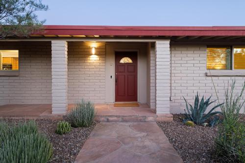 a house with a red door and a pathway at @TucsonMuralHouse w/pool & hot tub on golf course in Oro Valley