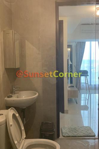 a bathroom with a white toilet and a sink at Sunset Corner @Pollux Habibie in Batam Center
