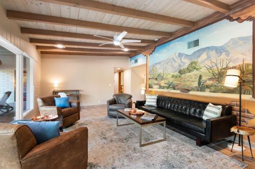 a living room with leather furniture and a painting on the wall at @TucsonMuralHouse w/pool & hot tub on golf course in Oro Valley