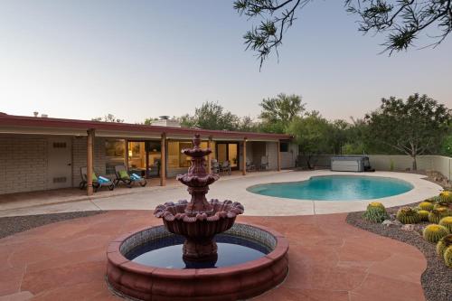 a fountain in front of a house with a pool at @TucsonMuralHouse w/pool & hot tub on golf course in Oro Valley