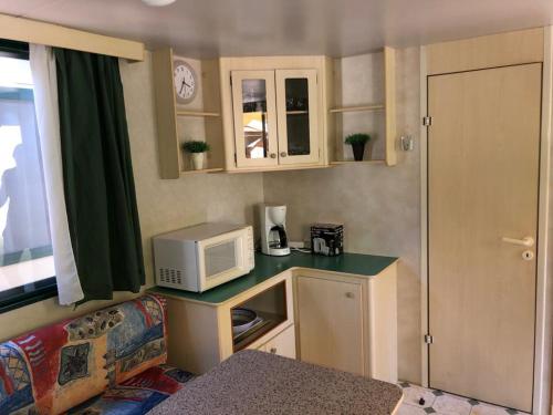 a small kitchen with a microwave on a counter at Zona Rosa 5 Chalet mit Klimaanlage und Wlan in Viareggio