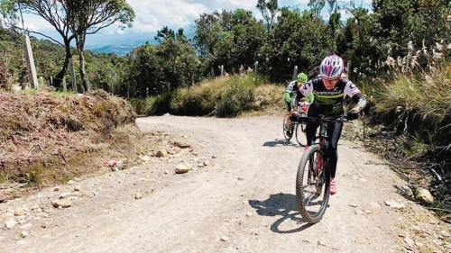 two people riding bikes on a dirt road at Altos de Quiluva in Suesca