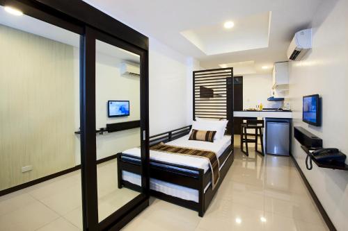a bedroom with a bed and a desk in a room at COPENHAGEN MAIN RESIDENCES in Cebu City