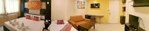 a living room with a couch and a television at Regent Suvarnabhumi Hotel in Lat Krabang