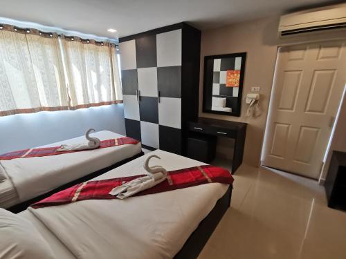 two beds in a hotel room with swans on them at Regent Suvarnabhumi Hotel in Lat Krabang