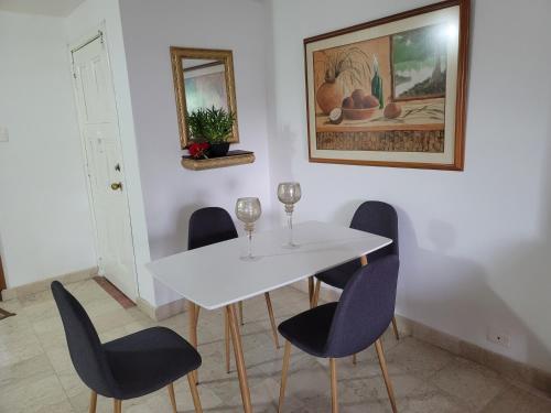 a dining room with a white table and chairs at PATUCA C4 in Santa Marta