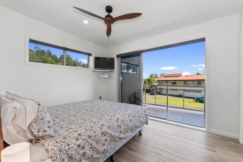 a bedroom with a bed and a large sliding glass door at Paihia Paradise - Paihia Holiday Home in Paihia