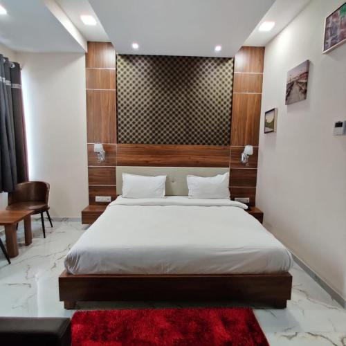 a bedroom with a bed and a red rug at Vadpadraka Hotel And Resort in Vadodara