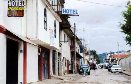 a street with cars parked on the side of a building at Hotel Tivoli in San Cristóbal de Las Casas