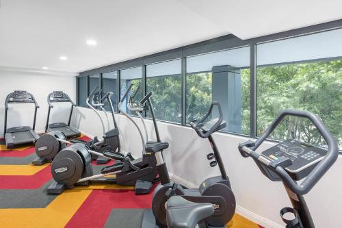 a gym with treadmills and elliptical machines at Meriton Suites North Sydney in Sydney