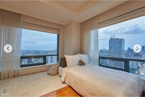 ein Schlafzimmer mit einem großen Bett und einem großen Fenster in der Unterkunft Corner Inn in Taichung