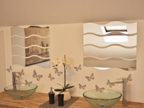 a bathroom with two sinks and butterflies on the wall at Villa Sunset in La Saline les Bains
