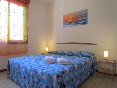 um quarto com uma cama com duas toalhas em Lovely flat with garden and pool - Beahost em Bibione