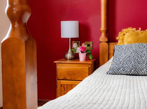 een slaapkamer met een bed en een lamp op een nachtkastje bij The Fountain Oldwood in Tenbury