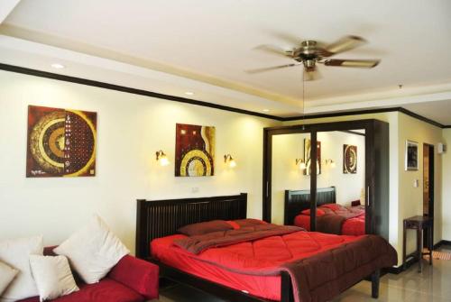 a bedroom with two beds and a couch at View Talay 5 studio apartment - close to the beach in Pattaya South