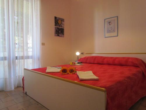 een slaapkamer met een groot rood bed en een rode deken bij Holiday in Bibione by the beach - Beahost in Bibione