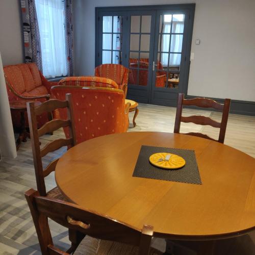 a wooden table and chairs with a plate on it at L'Avesnois in Fourmies