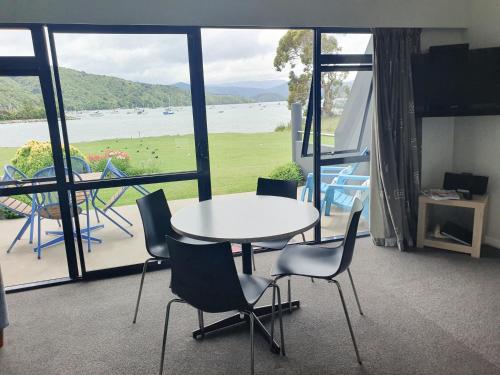 a table and chairs in a room with a large window at Bay Vista Waterfront Motel in Picton