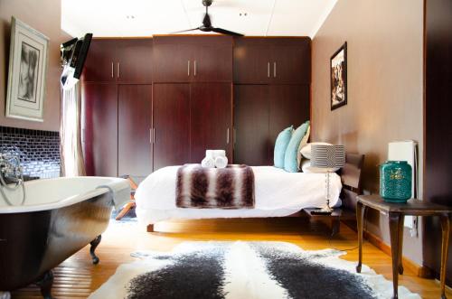 a bedroom with a bed and a bath tub and a bath tub at Desert Dew Guest House in Hutchinson