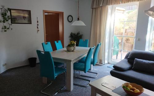 a living room with a table and blue chairs at Ferienwohnung-Rita in Altenau