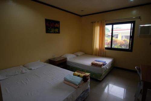 a hotel room with two beds and a window at Winter's Farm Resort in Milagros