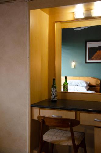 a bedroom with a desk with a mirror and a bed at Desert Dew Guest House in Hutchinson