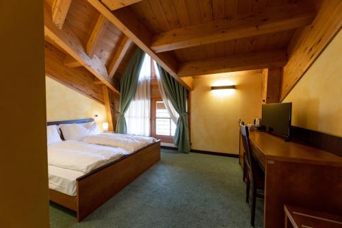 a bedroom with a bed and a tv in a room at Hotel Enzo Moro in Sùtrio