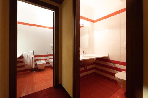 a bathroom with a toilet and a sink and a toilet istg at Hotel Enzo Moro in Sùtrio