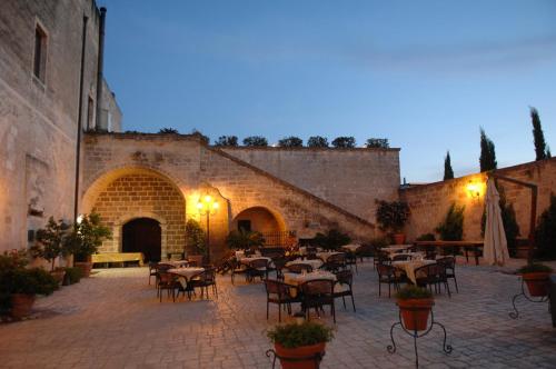 cortile con tavoli e sedie in un edificio di Castello Conti Filo a Torre Santa Susanna