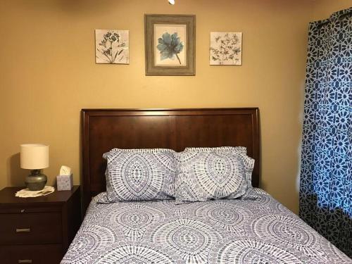 a bedroom with a bed with a wooden headboard and pillows at Cozy Pet-Friendly Home- Huge Spring Discounts in Spring