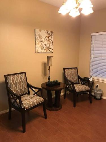 a living room with two chairs and a table and a lamp at Cozy Pet-Friendly Home- Huge Spring Discounts in Spring