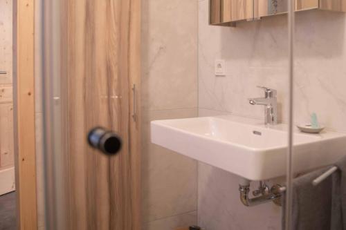 a bathroom with a sink next to a door at Apartments Kienberg in Kienberg