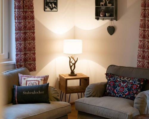 a living room with two chairs and a table with a lamp at Apartments Kienberg in Kienberg